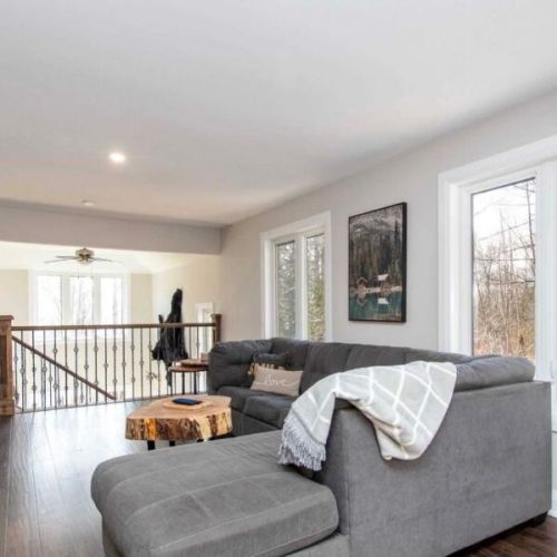 Comfortable open-concept lounge area with peaceful forest views.