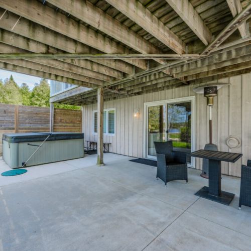 Unwind in Luxury: Jack's Retreat's hot tub area, a secluded spot for relaxation amidst the gentle sounds of nature and breathtaking views of the waterfront.
