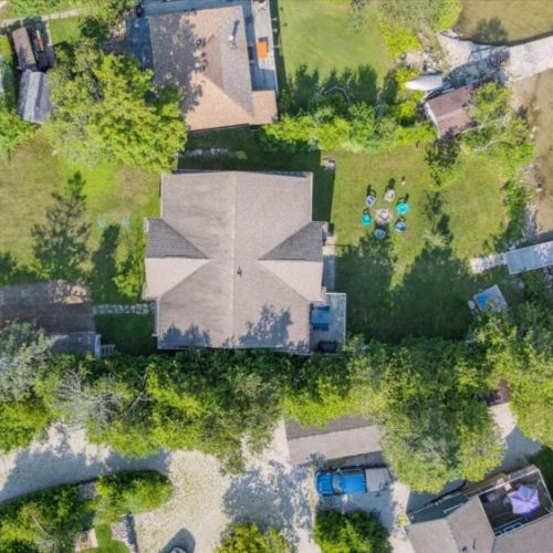 Aerial view of Watersedge showcasing the spacious backyard, lakeside fire circle, and private access to Miller Lake.