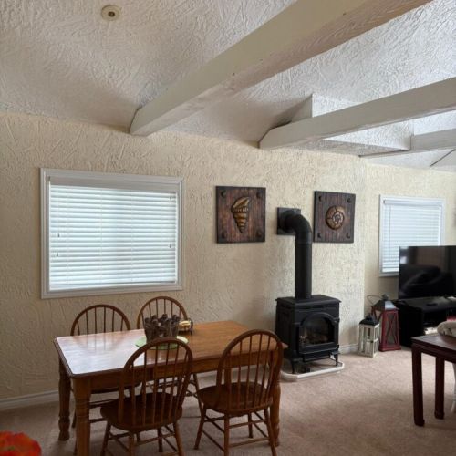 Classic cottage layout with a warm woodstove and a comfortable spot to gather.