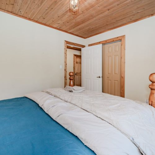 Cozy bedroom with wood accents and spacious closets—your private haven to unwind after a day of outdoor adventure.