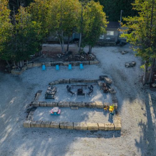 A fire pit seating area nestled among trees, perfect for evening gatherings and storytelling around a warm fire.