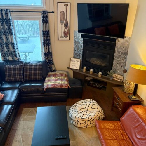 A warm living space with comfortable seating, fireplace, and TV. Perfect for relaxing evenings after a day of waterfront travel and outdoor adventure.
