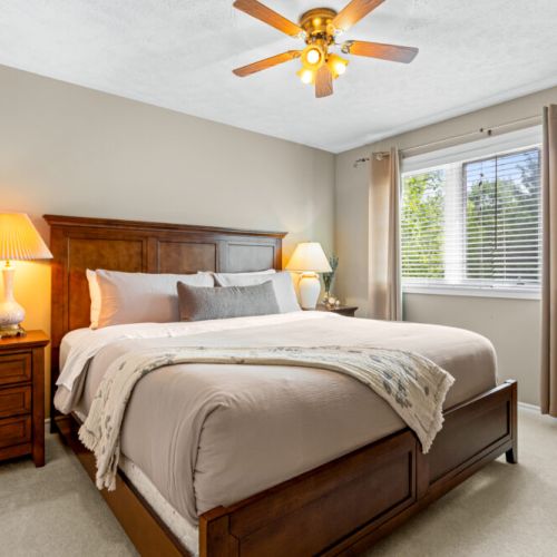 Rest and recharge in this comfortable king bedroom, featuring warm wood furnishings and plenty of natural light.