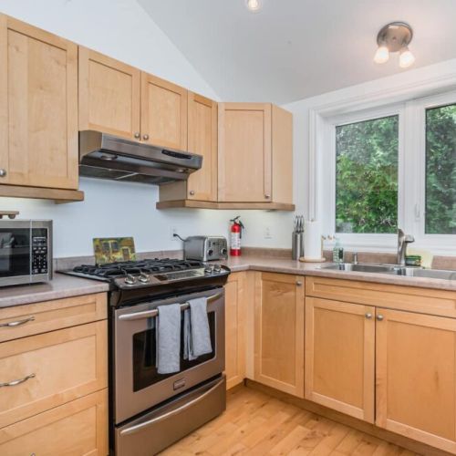 A fully stocked kitchen with gas stove, coffee maker, and microwave.
