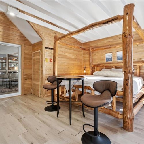 Rustic bedroom setup with a cozy bed, bar seating, and warm cabin-style character. A unique and comfortable space that feels both relaxed and inviting.
