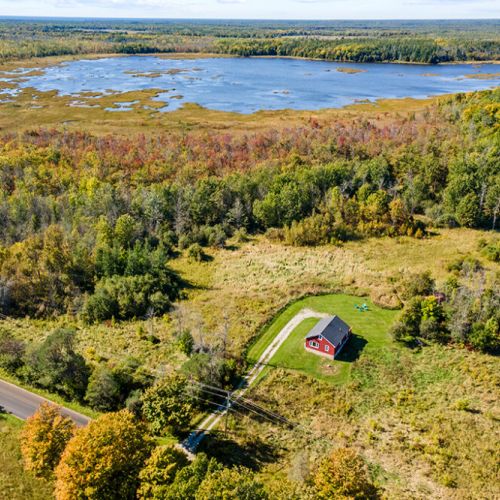A spectacular aerial view of Smith Homestead with the beautiful waters and wetlands of Ira Lake just beyond the surrounding forest.