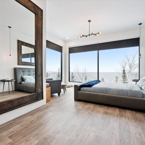 A serene, light-filled bedroom with clean lines, soft textures, and forest views—perfect for deep, restful sleep.