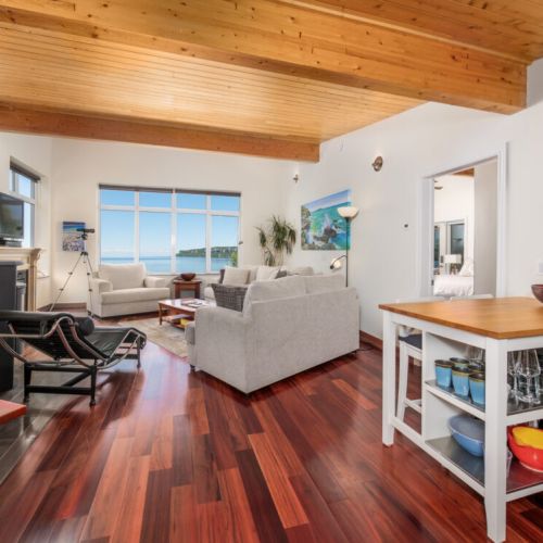 The bright, open-concept living space offers soaring ceilings, warm hardwood floors, and breathtaking Georgian Bay views.