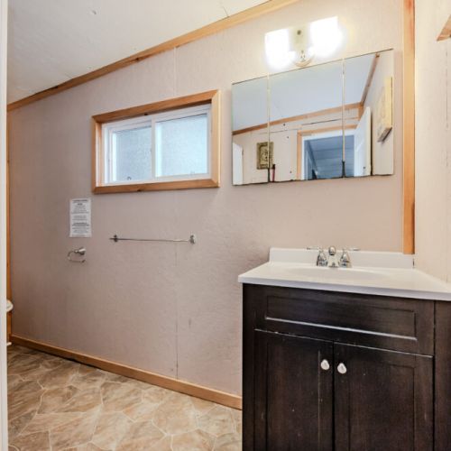 A clean and bright bathroom, equipped with a vanity and ample mirror space.