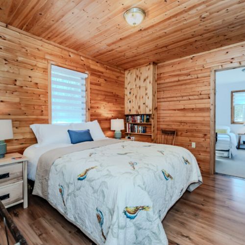 Inviting rustic bedroom with private reading nook and lush views, creating the ultimate cozy atmosphere for your lakeside getaway.