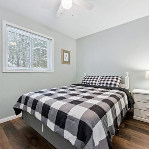 Bright and comfortable bedroom featuring a queen bed and tranquil forest outlook