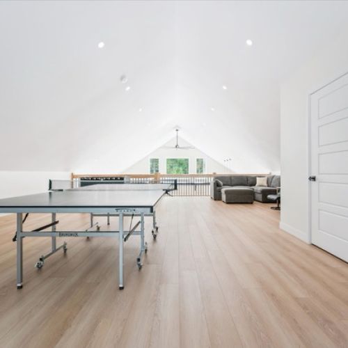 The upstairs games loft features ping pong, foosball, darts, and a lounge zone for movie nights or rainy-day hangouts.