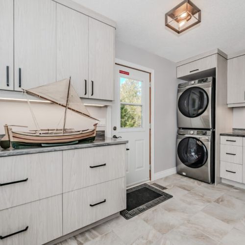 Bright and modern laundry room with full-size washer/dryer, deep sink, and ample storage—perfect for extended cottage stays, family vacations, or outdoor adventures that call for quick refreshes.