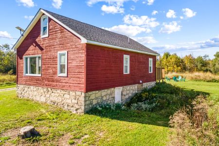 Classic farmhouse character shines through in the historic red exterior and stone foundation of Smith Homestead.