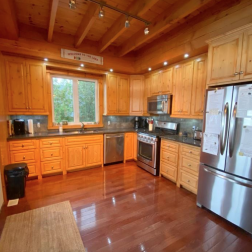 Prepare meals in this modern kitchen with high-end appliances and ample storage. The wood cabinetry adds a rustic charm, making it as beautiful as it is functional.