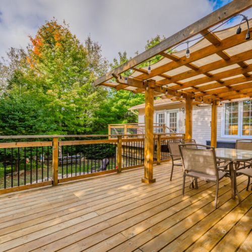 Dine al fresco on our spacious deck, complete with string lights for evening ambiance and surrounded by lush greenery.