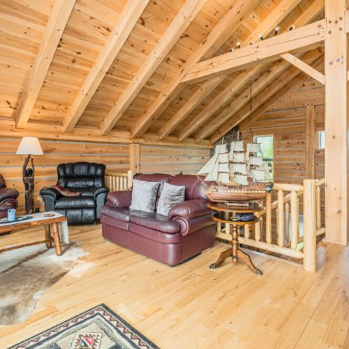 The loft includes a cozy lounge area, perfect for relaxing with a book or enjoying family games. The space is designed to offer both comfort and a sense of retreat.
