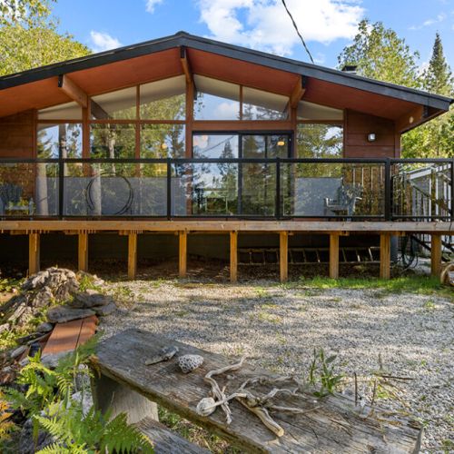 The spacious front deck is the perfect place to gather, relax, and enjoy the privacy of your woodland retreat.