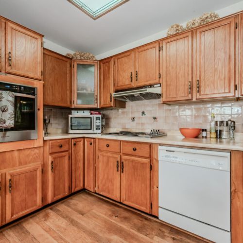 The kitchen is both functional and inviting, equipped with stainless steel appliances, including a modern stove and dishwasher.