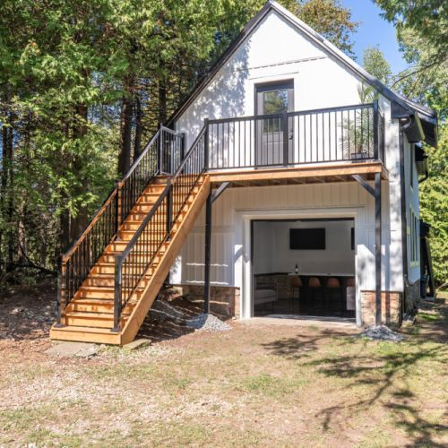 Separate garage loft hangout with an upper deck and private outdoor staircase.