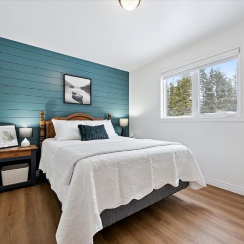 Peaceful bedroom retreat with cozy furnishings and calming woodland views—your perfect place to rest and recharge.