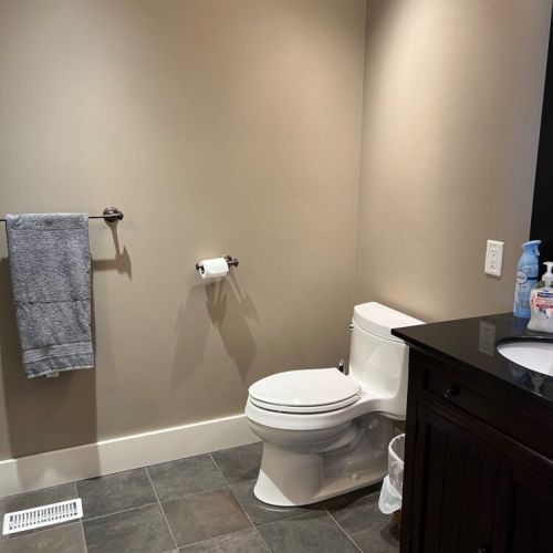 Modern bathroom, featuring a sleek vanity and tiled flooring for a simple yet refined look.