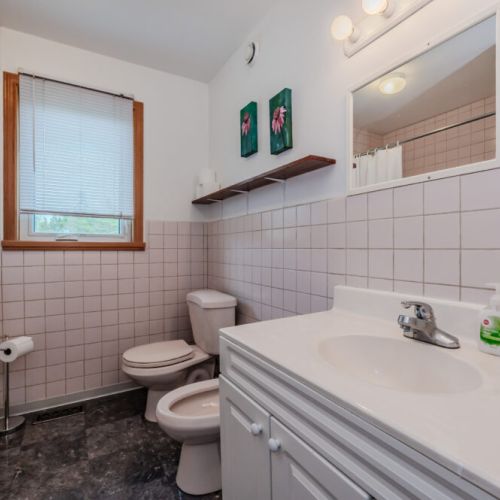 Clean and spacious full bathroom with a large vanity, natural light, and all the essentials for a comfortable stay.