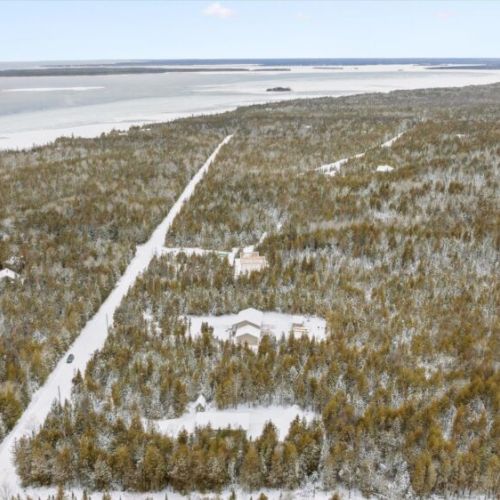 Aerial perspective highlighting Woodland Cottage’s location within a peaceful forested area, just minutes from the water.