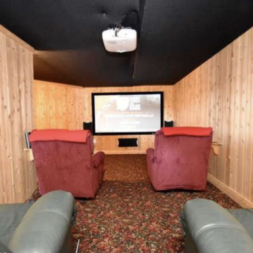 The cozy home theater with rustic wood paneling creates an inviting space for movie nights. Comfortable seating and optimal sound setup provide an immersive cinematic experience just for you!