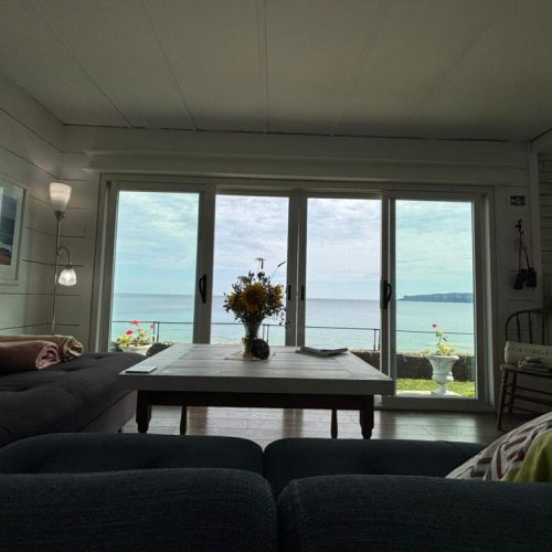 Floor-to-ceiling windows frame the bay from the comfort of your sofa.