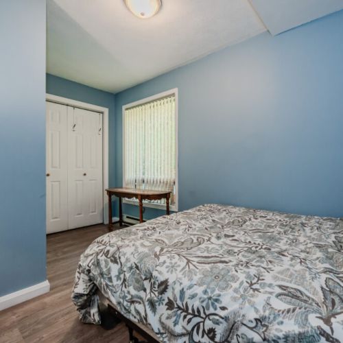 A second charming bedroom with simple decor and comfortable bedding, offering another peaceful retreat for guests.