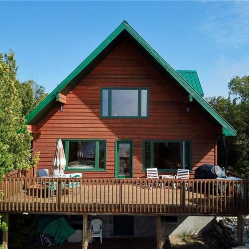 Welcome to Paradise Pines, a custom-built waterfront getaway with warm wood finishes and a bright open-concept design.