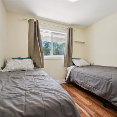 This comfortable twin bedroom offers a cozy and practical space for children, friends, or additional guests.