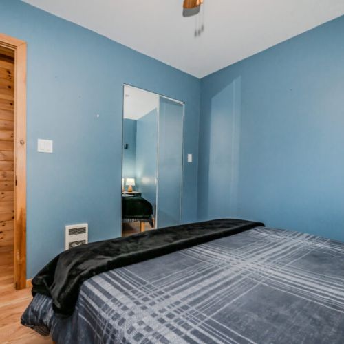 This cozy bedroom is designed for relaxation, with soft, modern bedding and a calming color palette. The room features convenient bedside tables and lamps, perfect for reading, along with closet space to store your belongings, ensuring a comfortable stay.