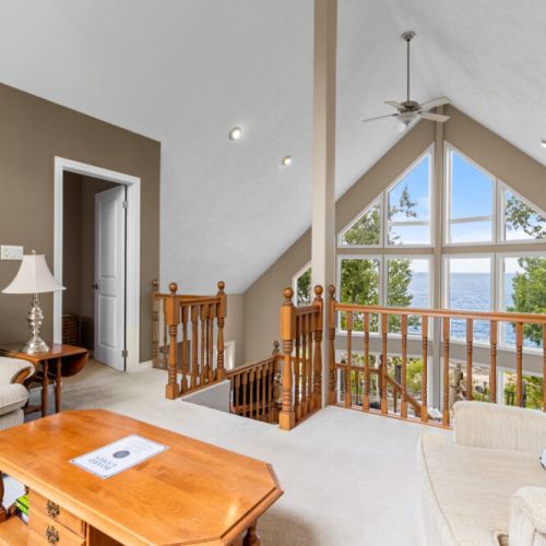 The upper-level loft offers a bright, open space to relax, with vaulted ceilings and beautiful views toward the water.
