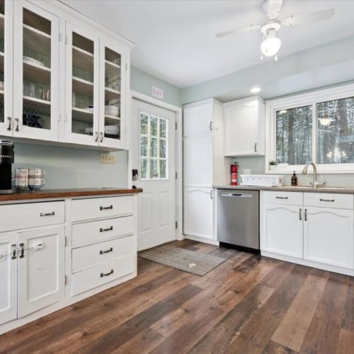 Bright kitchen with ample cabinetry, dishwasher, and easy access to dining area