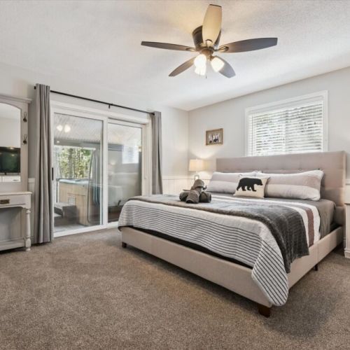 Spacious primary bedroom featuring a king bed, cozy furnishings, and direct access to the outdoor deck.