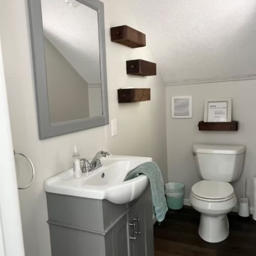 A charming half bath on the upper level — conveniently located near the loft and bedrooms, with fresh towels and simple, modern style.