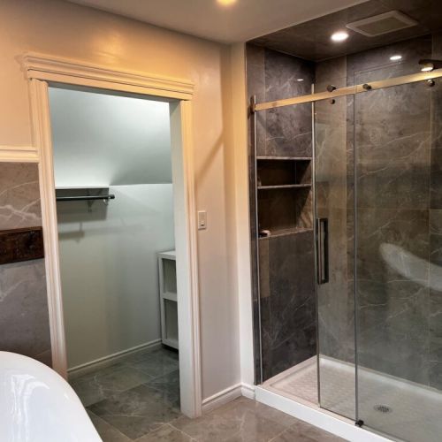 Walk-in glass shower with nearby walk-in closet for convenient storage