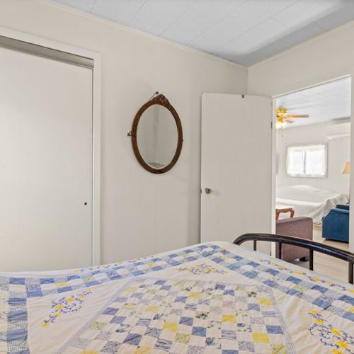 A simple, comfortable bedroom with convenient closet storage and easy access to the main living area.