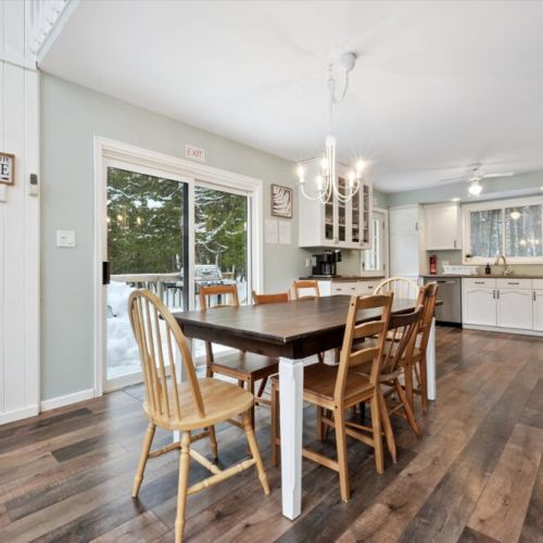 Open-concept dining area with large table, sliding doors, and easy kitchen access