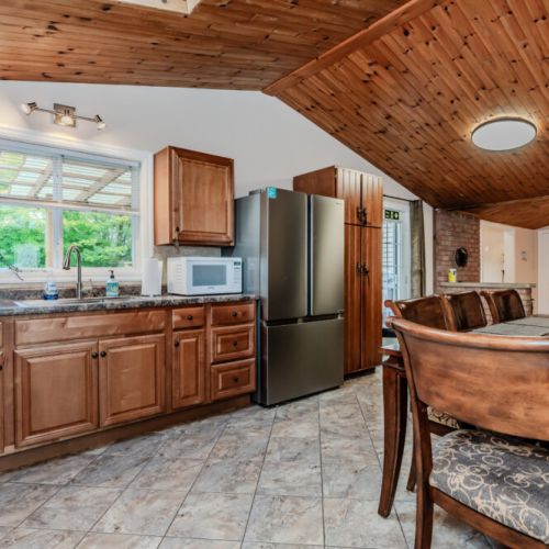 Cook with ease in this modern kitchen that offers plenty of counter space, stainless steel appliances, and views of the outdoor greenery.
