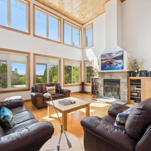 Stunning great room with soaring ceilings, fireplace, and floor-to-ceiling windows.