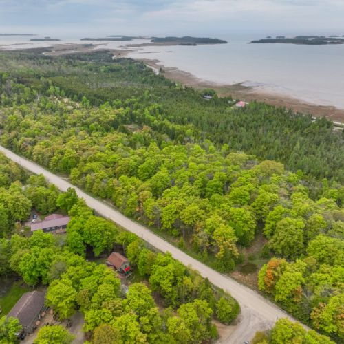 The scenic route leading to the cottage offers breathtaking views of the lush forest and the nearby waterfront, enhancing the sense of escape and tranquility.