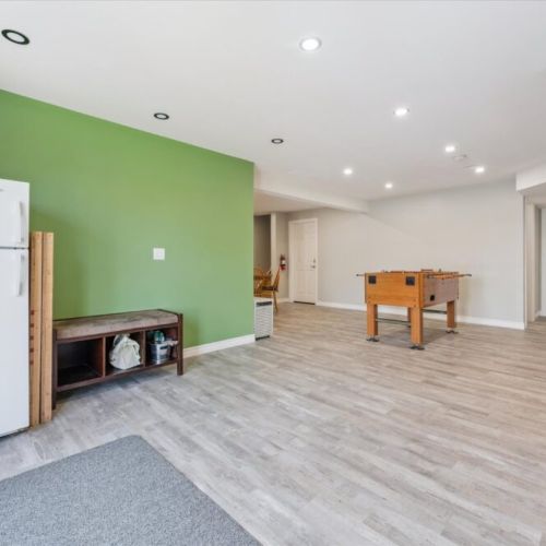 Lower-level retreat featuring foosball, extra fridge, and direct walkout access to the lake — the ultimate hangout space.