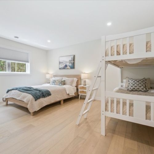 The perfect family suite — this bright and inviting bedroom features a queen bed and cozy bunk beds, ideal for restful nights and kid-friendly comfort.