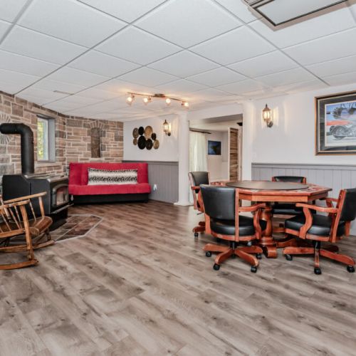 🪵 **Cozy Entertainment Den**  
Relax fireside or gather for games in this inviting lower-level retreat featuring a wood stove, poker table, and lounge space—perfect for après-adventure fun on your nature escape or group vacation.