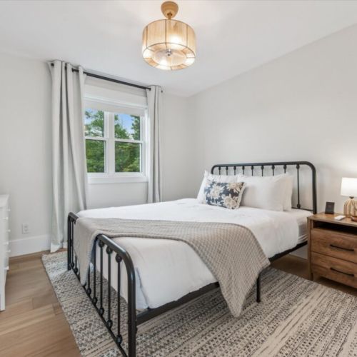 Unwind in this cozy, light-filled bedroom with soft linens and neutral tones—a restful haven after a day of exploring.