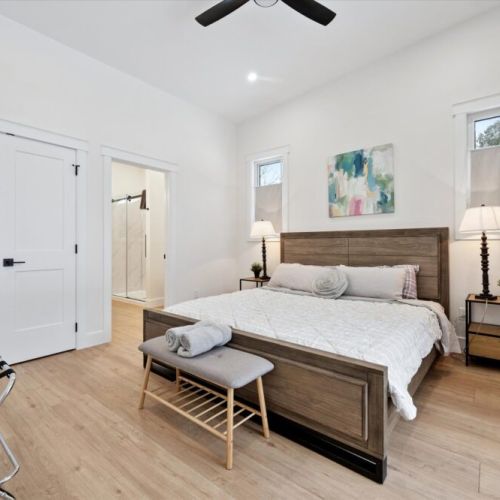 Primary bedroom retreat featuring a queen bed, bench seating, and private ensuite access.